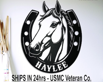 May include: Black metal horse head silhouette within a horseshoe, with the name "HAYLEE" at the bottom. The sign is made of 14-gauge American steel. The text "crossmetalworks" is at the top left.