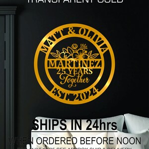 K&ouml;nnte beinhalten: Goldfarbene Metall-Wandkunst mit den Schriftz&uuml;gen "MATT & OLIVIA" und "MARTINEZ 25 YEARS Together EST. 2024". Das Design umfasst florale Elemente in einem kreisf&ouml;rmigen Rahmen, ideal als Hochzeits- oder Jubil&auml;umsgeschenk.