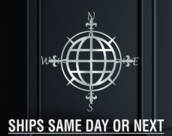 May include: A polished silver compass with a globe design and the letters N, S, E, and W. The text "SHIPS SAME DAY OR NEXT WHEN ORDERED BEFORE NOON" is below the compass.