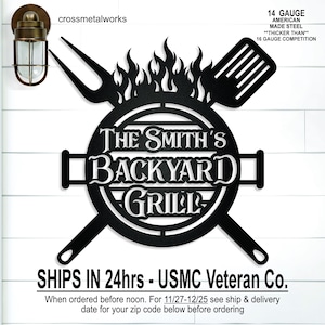 May include: A black metal wall sign featuring a circular grill design with flames, a fork, and a spatula. The text reads THE SMITH'S BACKYARD GRILL. Additional text includes 14 GAUGE AMERICAN MADE STEEL, THICKER THAN 16 GAUGE COMPETITION, and crossmetalworks.