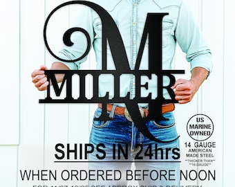 May include: A black metal personalised family name sign with a large initial "M" and the last name "Miller" below. The sign is held by a person wearing a blue shirt and jeans. The sign is 14 gauge American made steel and is thicker than 16 gauge.