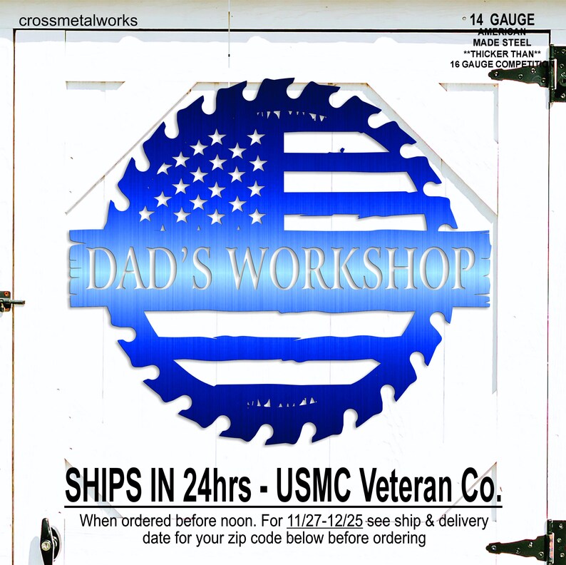 Op de afbeelding: Een blauw metalen bord met de tekst "DAD'S WORKSHOP" in een gestileerd lettertype. Het bord heeft de vorm van een zaagblad en heeft het ontwerp van de Amerikaanse vlag. Het bord is gemaakt van 14 gauge staal.