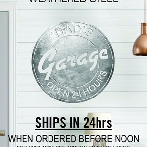 Pode incluir: Uma placa de a&ccedil;o desgastado com o texto "DAD'S Garage OPEN 24 HOURS" em letras brancas. A placa tem um visual desgastado e vintage, perfeito para uma garagem ou oficina.