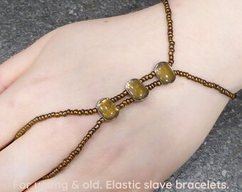 Copper metallic. Topaz enamel in nickel free metal spacer bars. Elastic slave bracelet. Bracelet ring. Hand jewellery. Finger bracelet.