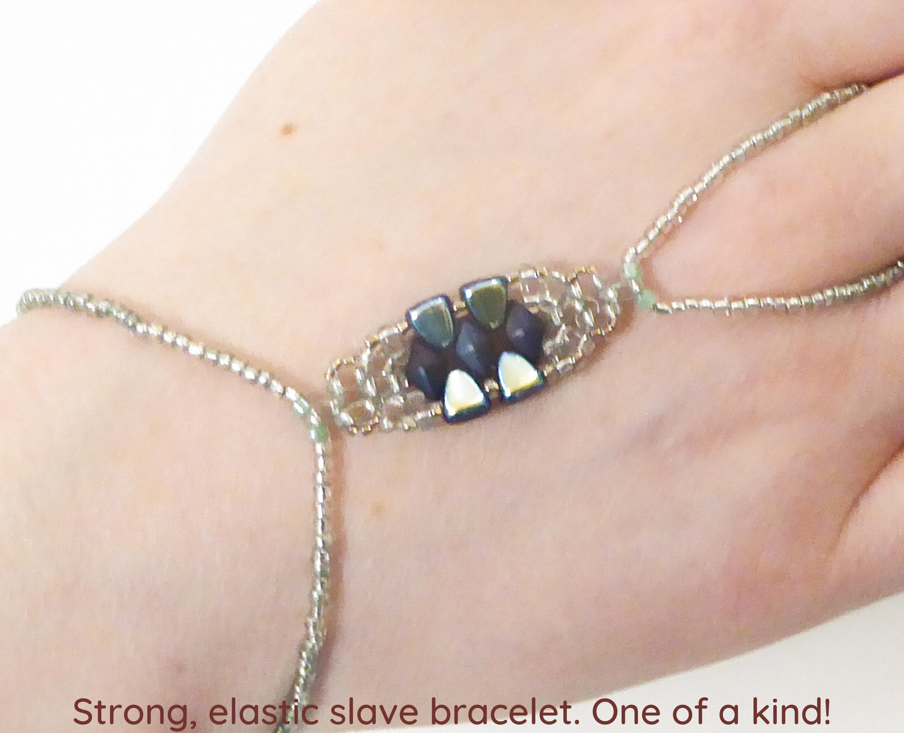 Sparkling and shiny blue green Nib-Bit. Blue DiamondDuo. Pale blue green Twin beads. Gold lined crystal seed beads. Elastic slave bracelet.