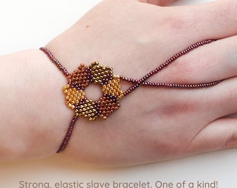 Beadwork flower with different gold & copper metallic delica beads. Elastic slave bracelet. Gold metallic delica beads. Ring bracelet.