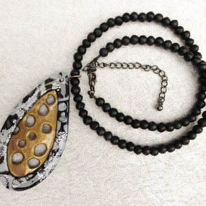 Gold polymer clay net, a frame of black and sparkling silver polymer clay. Black irregular glass beads. Black colored clasp and chain. image 2