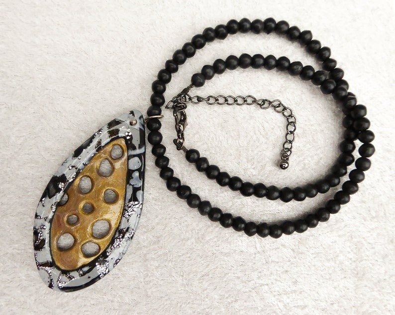 Gold polymer clay net, a frame of black and sparkling silver polymer clay. Black irregular glass beads. Black colored clasp and chain. image 2