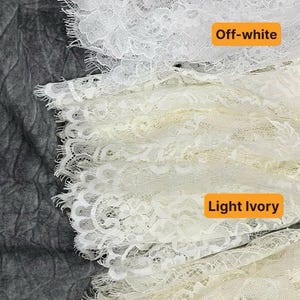 May include: Three strips of delicate floral lace trim with scalloped edges, arranged vertically. The top strip is labeled Off-white, the middle strip is labeled Light Ivory, and the bottom strip is labeled Dark Ivory, showing color variations.