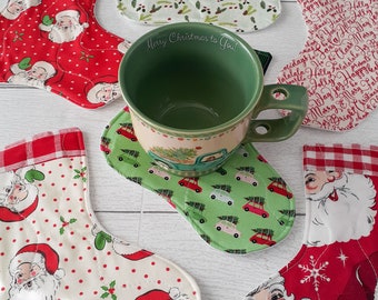 Op de afbeelding: Set van zes kerst-geïnspireerde stoffen onderzetters in de vorm van kousen. De onderzetters hebben verschillende ontwerpen, waaronder Sinterklaas, hulst en een rood-wit geruit patroon. De onderzetters zijn perfect om oppervlakken te beschermen tegen hete mokken en bekers.