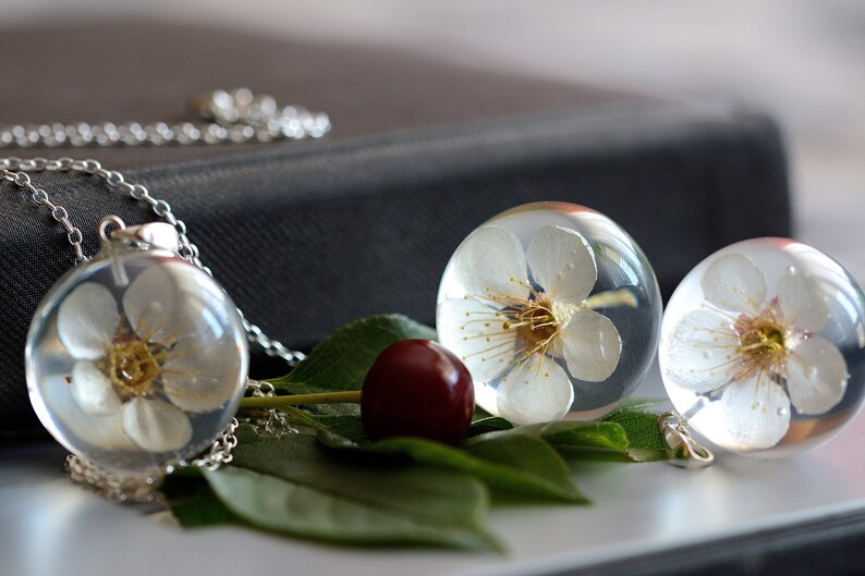 in the resin ball on a silver chain Pendant with natural white cherry flower Chain 80 cm. Sphere 3 cm Prunus sp.