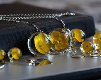 Unique pendant with real bulbous buttercup (Ranunculus bulbosus) in the resin sphere on a silver chain. Sphere 2.5 cm or 3 cm. Chain 80 cm.