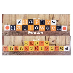 May include: A wooden sign with interchangeable blocks that spell out "Happy Halloween" on one side and "Happy Thanksgiving" on the other. The blocks are painted in orange, yellow, and black with black lettering. The sign is reversible.