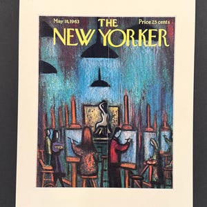 May include: A vintage print of The New Yorker magazine cover from May 18, 1963. The cover art shows an art studio scene with figures painting at easels. The background is a mix of blue, green, and brown hues, with the magazine title in yellow.