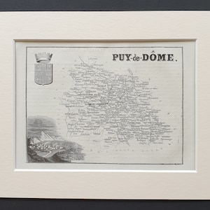 May include: A monochrome map of Puy-de-Dôme, France, presented in a white mount. The map features the region's name, a coat of arms, and detailed geographical elements. The map is set against a black backdrop.