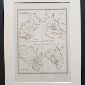 Può includere: Una stampa di mappe d'epoca incorniciata con quattro mappe dettagliate di città: Huddersfield, Ripon, Halifax e Knaresborough. Ogni mappa è delineata in rosso, con dettagli interni in bianco e nero. La stampa è incorniciata in bianco.