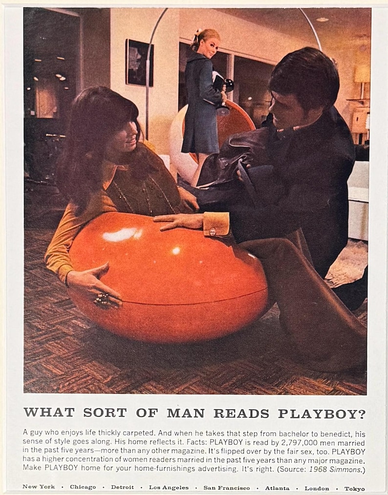 May include: A vintage 1968 magazine advertisement featuring a large, glossy orange egg-shaped chair. The text reads: WHAT SORT OF MAN READS PLAYBOY? A guy who enjoys life thickly carpeted. And when he takes that step from bachelor to benedict, his sense of style goes along.