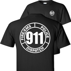 May include: Black t-shirt with a white circle graphic on the back. The circle graphic says "FIRE/EMS POLICE 911 DISPATCH".