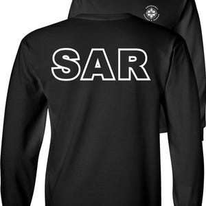 May include: Black long-sleeved shirt with the white letters "SAR" on the back. The shirt also features a white graphic on the front that says "Emergency Search & Rescue".