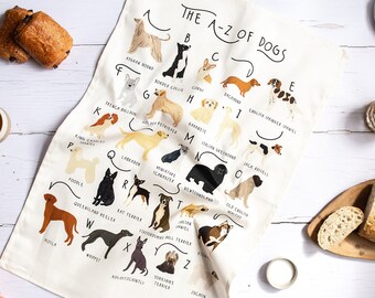 Può includere: Un asciugamano da cucina bianco con un alfabeto illustrato di razze di cani. Ogni lettera è abbinata al nome di una razza di cane e a una piccola illustrazione del cane. Il testo in cima all'asciugamano recita "The A-Z of Dogs".