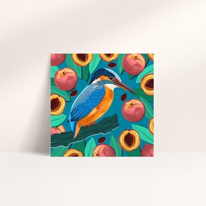 May include: A blue and orange kingfisher bird perched on a branch with a background of peach fruit and green leaves. The bird has a long, pointed beak and a blue head. The peaches are ripe and juicy, with a yellow flesh and a red skin.
