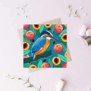 May include: A blue and orange kingfisher bird perched on a branch surrounded by peach slices on a teal background.