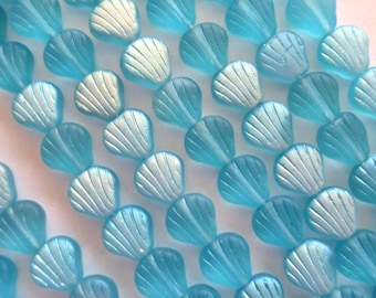 May include: A strand of light blue glass beads shaped like seashells with iridescent accents.