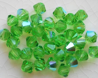 Lotto di 24 perle biconiche sfaccettate in vetro Peridot AB ceco da 4 mm, biconi Preciosa Green AB 5601