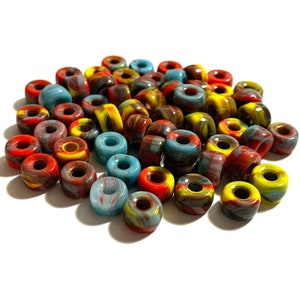 May include: A pile of colorful, swirl-patterned skateboard wheels. The wheels are red, yellow, blue, and black.