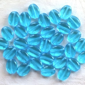 25 przezroczystych, płaskich, owalnych, czeskich szklanych koralików w kolorze Aqua Blue, 12 mm x 9 mm, prasowane szklane koraliki C7425