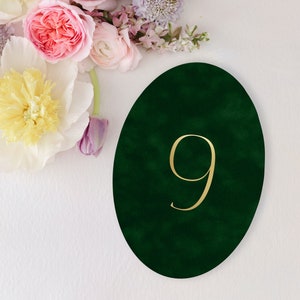 May include: A green velvet oval table number with the number 9 in gold lettering.