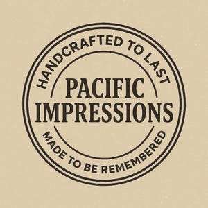 A black and white circular logo with the text "HANDCRAFTED TO LAST" and "PACIFIC IMPRESSIONS" inside it.