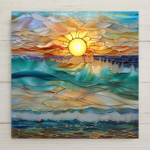 May include: A square stained glass panel depicting a sunset over the ocean. The scene features a bright yellow sun, orange and gold clouds, and deep teal and blue waves. The glass pieces are joined by dark metal lines, creating a textured mosaic.