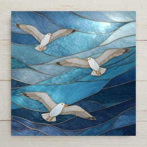 May include: A square wall art piece featuring a stained glass style design of three white seagulls with grey wingtips flying over abstract, swirling waves in various shades of blue, ranging from light cyan to deep navy, separated by thin dark lines.