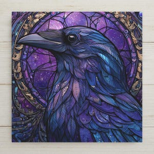 May include: A square wall art print featuring a detailed illustration of a raven in profile. The bird has iridescent blue and purple feathers. It is framed by a circular, stained-glass style border with gold accents against a starry purple background.