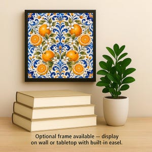 May include: A square wall art piece featuring a vibrant pattern of oranges, green leaves, and white blossoms set against a blue and white scrollwork background, enclosed in a black frame. The text reads: Optional frame available.