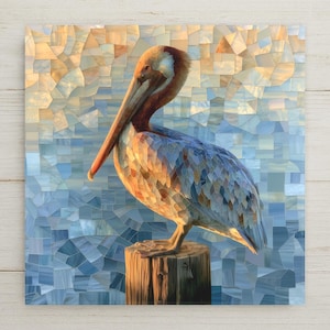 May include: A square wall art print featuring a mosaic-style illustration of a brown pelican perched on a wooden post. The bird displays warm orange, brown, and blue tones, set against a fragmented, geometric background of soft blue and gold hues.