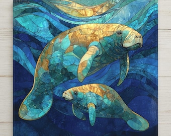 May include: A square wall art piece featuring a stained glass style illustration of two manatees swimming in deep blue water. The manatees are rendered in shades of gold, teal, and blue, with dark outlines creating a mosaic effect throughout the image.