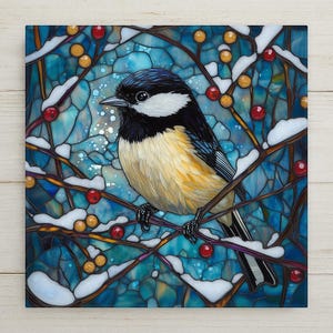 May include: A square art print featuring a bird perched on a branch with red berries and snow. The bird has black, white, and yellow feathers. The background is a mosaic of blue and turquoise hues.