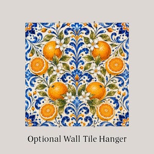 May include: A square ceramic tile featuring a symmetrical pattern of bright orange citrus fruits, white blossoms, and green leaves set against a cream background with intricate blue and gold scrolling acanthus leaf motifs and the text Optional Wall Tile Hanger.