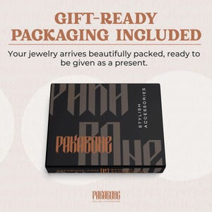 May include: A black gift box with the text "GIFT-READY PACKAGING INCLUDED" and "Your jewelry arrives beautifully packed, ready to be given as a present." The box has the brand name "PAKABONE" in a stylized font.