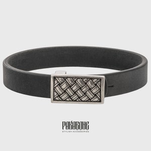 Pode incluir: Um bracelete de couro preto com um fecho prateado com um padr&atilde;o tecido. O bracelete &eacute; etiquetado como "PAKABONE STYLISH ACCESSORIES".