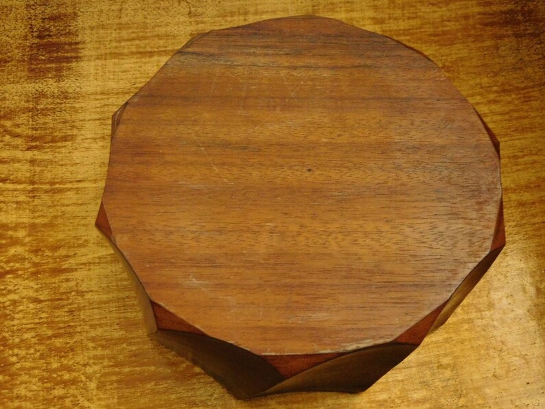 May include: A wooden octagonal tray with a smooth, dark brown finish. The tray is made of solid wood and has a natural grain pattern.