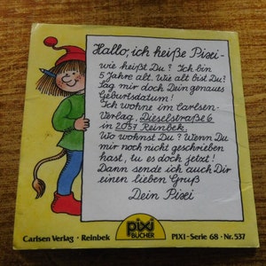 Puede incluir: Una portada de libro ilustrada en amarillo y rojo con un personaje de dibujos animados que sostiene un cartel que dice "Hallo, ich hei&szlig;e Pixi - wie hei&szlig;t Du?" El libro se titula "Pixi-Serie 68 - Nr. 537" y es publicado por Carlsen Verlag, Reinbek.