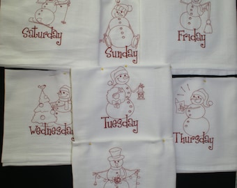 May include: Seven white kitchen towels with embroidered snowman designs and the days of the week. Each towel features a different snowman design and the corresponding day of the week in red embroidery.