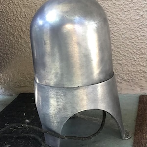 May include: A vintage, brushed aluminum lamp with a rounded top and a curved base. The lamp has a cylindrical shape with a band around the middle. A black electrical cord extends from the base.