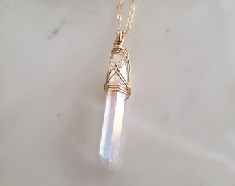 May include: A gold chain necklace with a iridescent crystal pendant wrapped in gold wire.