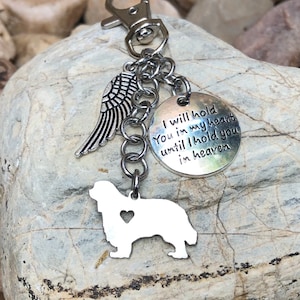 Könnte beinhalten: Silberner Schlüsselanhänger mit einer Hundesilhouette, Engelsflügeln und einem Anhänger mit der Aufschrift "Ich werde dich in meinem Herzen halten, bis ich dich im Himmel halte".