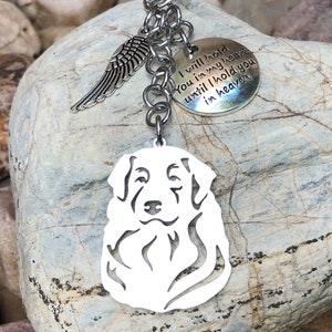 Puede incluir: Llavero de plata con una silueta de perro, un pequeño amuleto de ala de ángel y un amuleto redondo con el texto "Te guardaré en mi corazón hasta que te tenga en el cielo".