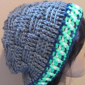 May include: Gray knitted beanie with a blue, white, and green striped trim.